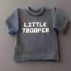 Newborn wearing personalized Little Trooper baby knit outfit, handmade with soft yarn, ideal for military families and baby showers.
