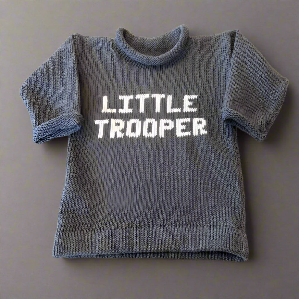 Newborn wearing personalized Little Trooper baby knit outfit, handmade with soft yarn, ideal for military families and baby showers.